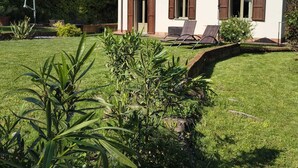 A two-story house with a white exterior, brown shutters, and a small balcony. - Villa La Bolvedrina: private garden with BBQ, 100 meters from the Lake. (Tremezzina)