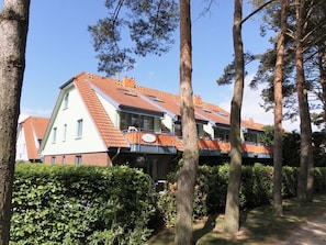 A building with a sloped roof, multiple windows, and a balcony.