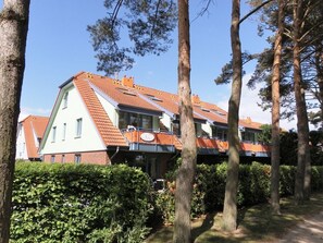 Rakennuksessa on kalteva katto, useita ikkunoita ja parveke.