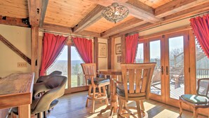 A wooden interior with a dining table, chairs, and a chandelier. - Timeless Red Sox Retreat w/ Scenic Mountain Views! (Putney)