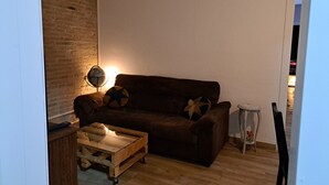 A cozy living room with a brown sofa, a wooden coffee table, and a globe on a side table. - Casa Antique Barcelona&Barca (Hospitalet de Llobregat)