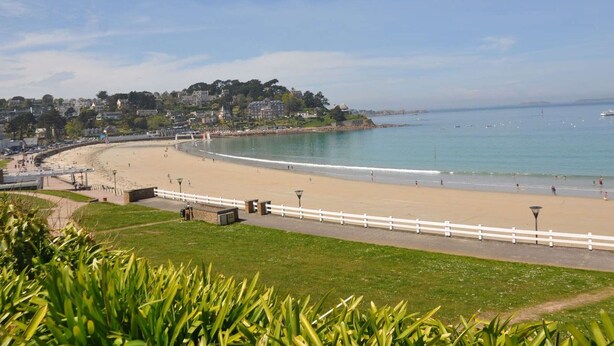 A coastal beach with a white fence, a pathway, and a grassy area in the foreground. - New apartment 2/4 people, 100m to beach, Perros-Guirec (Perros-Guirec)