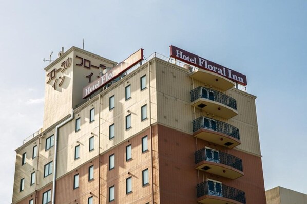 A multi-story hotel with balconies and a sign reading 'Hotel Floral Inn.'
