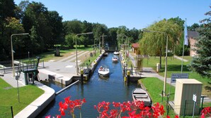A canal with boats, a pedestrian bridge, and a small building with a sign. - Apartment "SeeLiebe" in Bad Saarow (Bad Saarow)