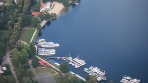 An aerial view of a marina with several large cruise ships docked, surrounded by residential buildings and greenery. - Apartment "SeeLiebe" in Bad Saarow (Bad Saarow)