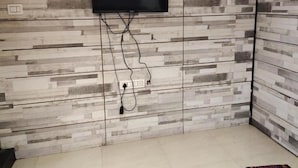 Habitación con televisión de pantalla plana montada en una pared con diseño que imita la madera.