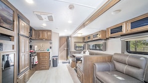 Enjoy meals in the dining area with a table and bench, adjacent to the fully equipped kitchen.