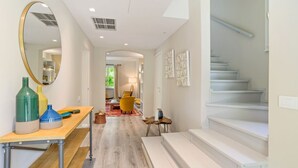 A modern interior with a wooden floor, a mirror, a table with bottles, a staircase, and a yellow chair. - Bright and welcoming two-level villa with large garden, just 5km from Bellagio and 2.5km from the pretty village of Civenna! The villa is located halfway between the picturesque Bellagio (a stunning town on the Como Lake) and Mount S.Primo, which offers  (Gallasco-cernobbio)