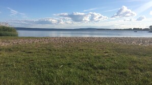 Een strand met een heldere lucht en rustig water.
