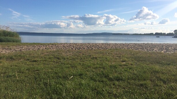 A beach with a clear sky and calm water.