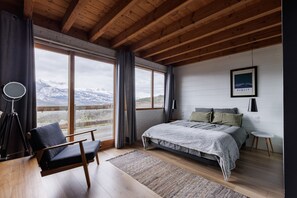 Relax in this serene room with a large bed, a single chair, and a stunning mountain view.