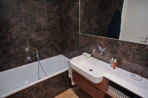 A modern bathroom with a bathtub, a sink, and a mirror. - Maison Art Gallery, just a few steps from the Duomo! (Milano)