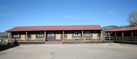 A two-story building with a red roof and a wooden deck.