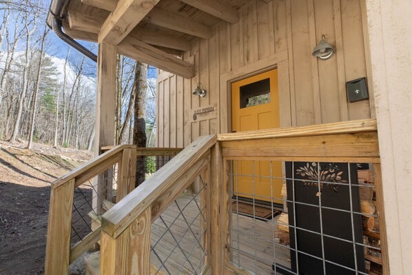 Une cabane en bois avec un escalier en bois menant à une porte sur laquelle est inscrit « JULY PIPPIN ».
