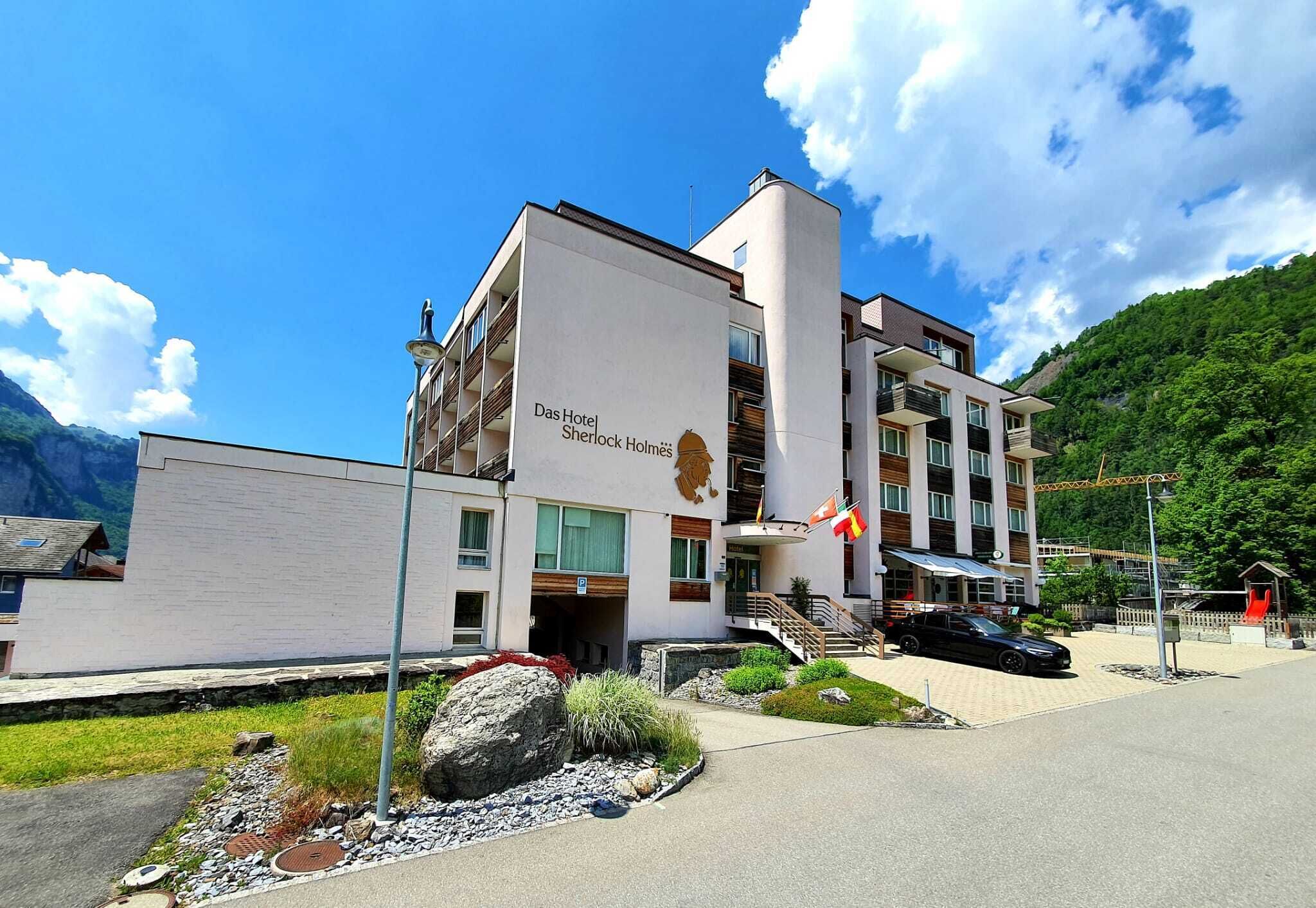 A modern hotel with a flat roof, a lion emblem, and a flag.