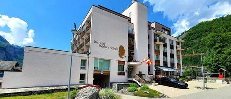 A modern hotel with a flat roof, a lion emblem, and a flag.