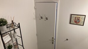 Une salle de bain avec une porte blanche, un petit lavabo et un tableau encadré au mur.
