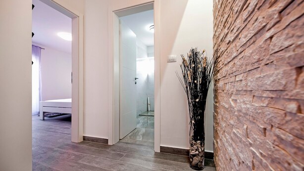 Un couloir comprenant un lit, une douche et un vase décoratif.