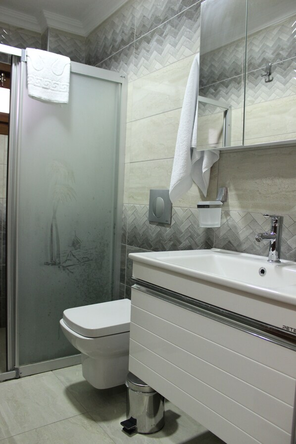 A bathroom with a toilet, sink, and shower.