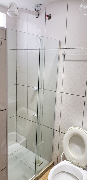 A glass-enclosed shower stall with a white toilet to the right. - Pousada Caminho do Pontal (Arraial do Cabo)