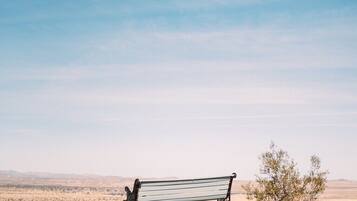 A solitary bench in a desert landscape with a clear sky.