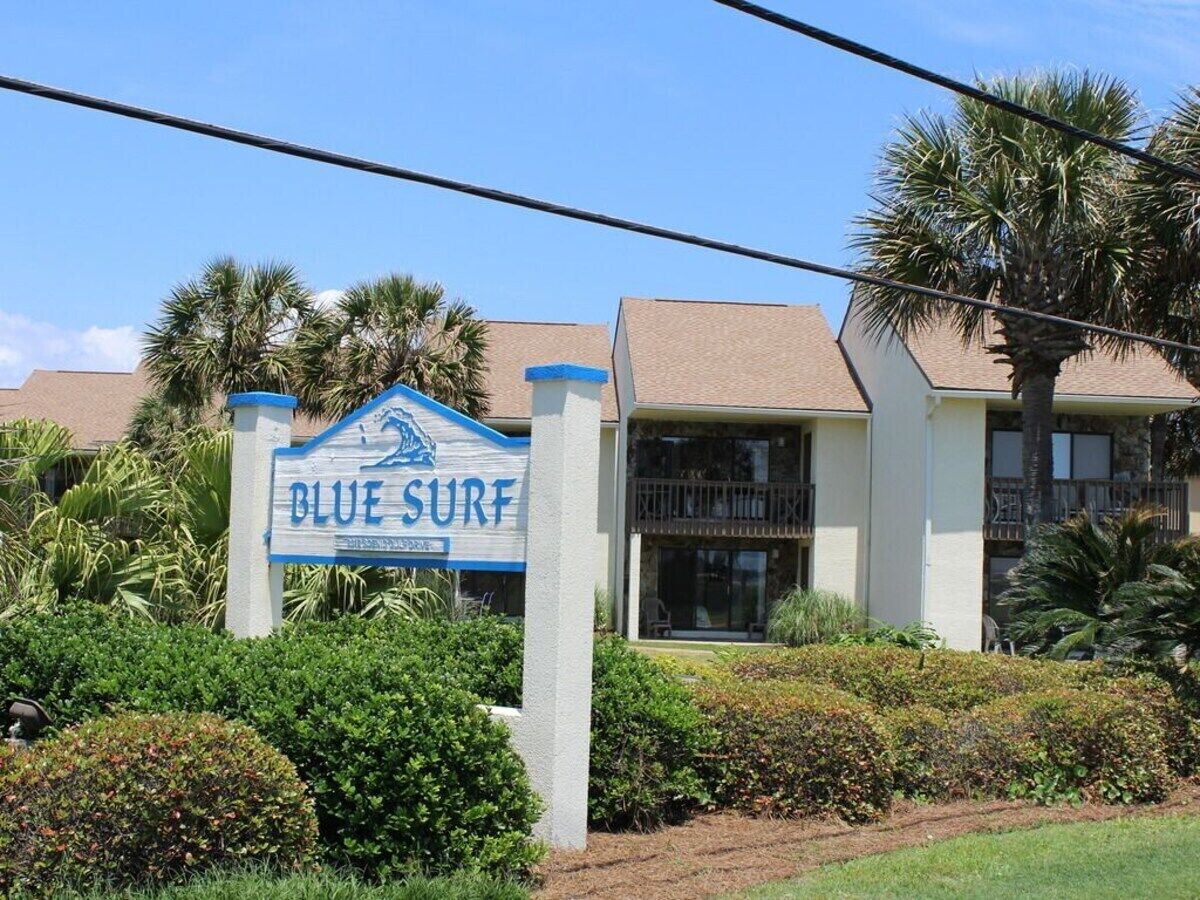 Een bord met 'Blue Surf' en een gebouw op de achtergrond.