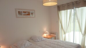 A bedroom with a bed, bedside table, lamp, and a framed picture on the wall. - GUIDEL BEACHES HOLIDAY HOME NEAR THE BEACHES (Guidel)