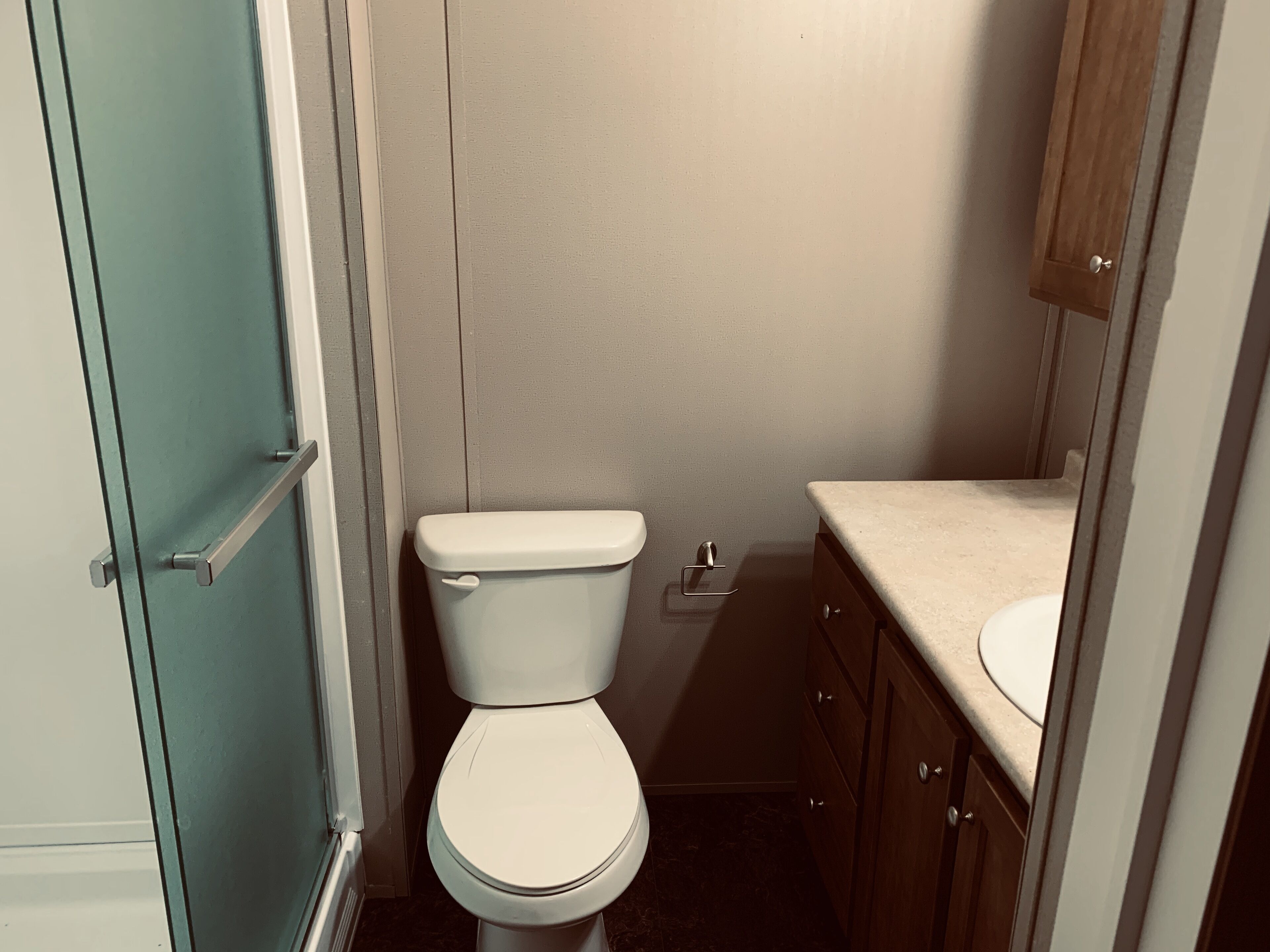 Un baño pequeño con inodoro, lavabo y muebles de madera.