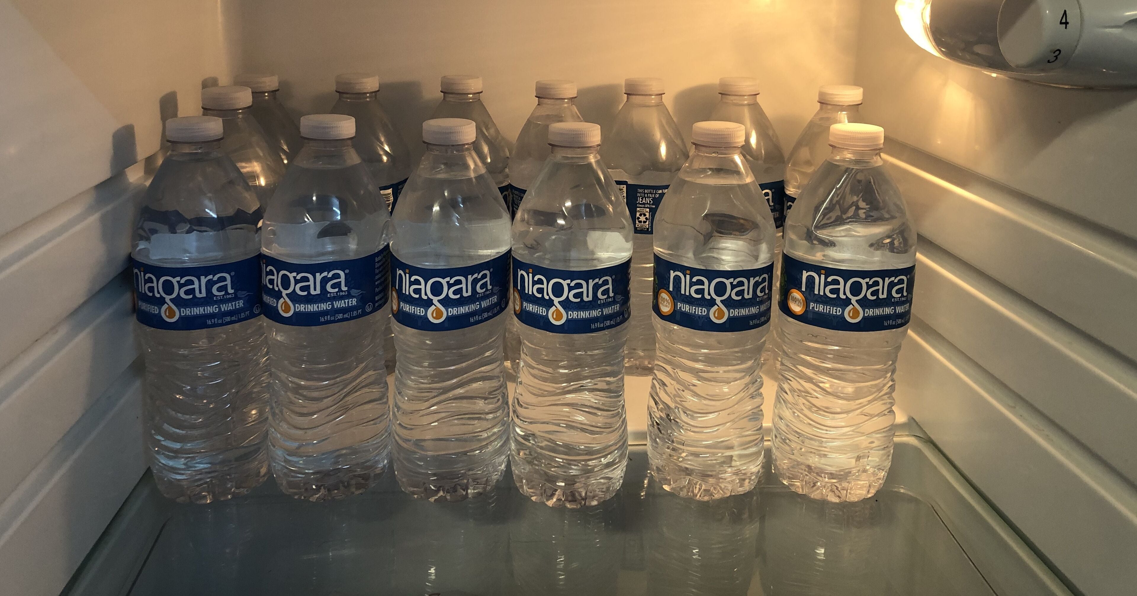 A refrigerator stocked with bottled water.