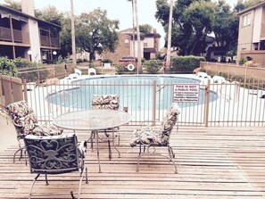 A private pool area with a sign indicating it's not a public pool. There are lounge chairs and a table on a wooden deck.