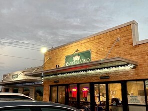 A diner with a brick facade and a green awning displaying the name 'Rancho Viejo'.