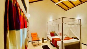 Un dormitorio con cama con dosel, una silla y un ventilador de techo.