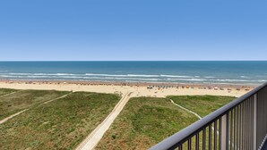 Ein Strand mit blauem Himmel, ein Weg zum Strand und Strandstühle.