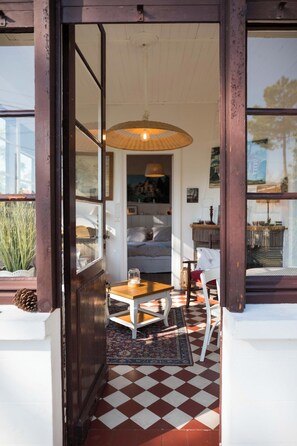 A dining area with a checkered floor, a wooden table, and a hanging light fixture. - Villa Arcachonaise on the 2nd line of the basin, a few metres from the beach (Claouey, Lège-Cap-Ferret)