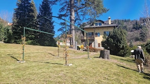 A house with a balcony, surrounded by a grassy area and trees. - Villa Rosa - villa surrounded by greenery with private garden, ideal for families (Pian Nava)