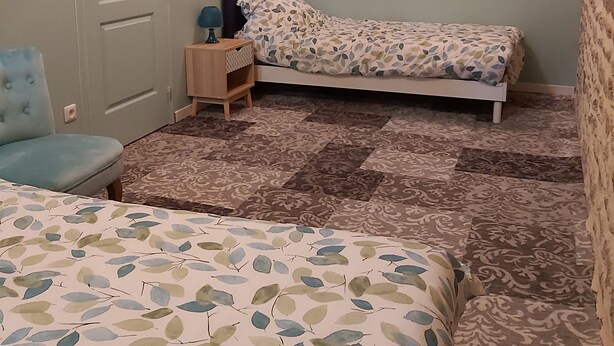 Ein Schlafzimmer mit einem Bett, einem Sessel, einem Nachttisch und einem Kleiderschrank.