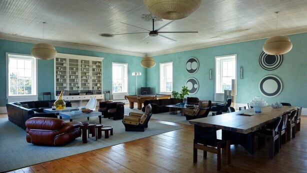A spacious living room with a high ceiling, a large wooden dining table, and comfortable seating. - Luxury Apartment overlooking Center Harbor in Brooklin (Brooklin)