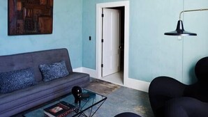 A room with a blue wall, a wooden ceiling, a sofa, a coffee table, and a door. - Luxury Apartment overlooking Center Harbor in Brooklin (Brooklin)