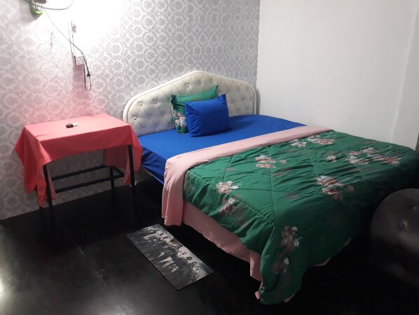 Ein Schlafzimmer mit einem Bett, einem Tisch und einer Wand mit Muster.