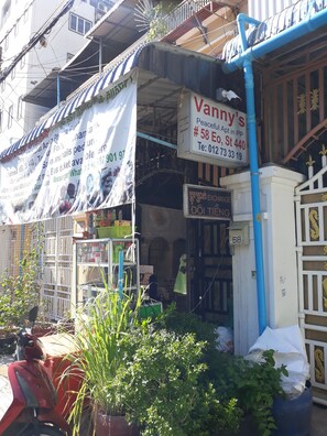 Ein Gebäude mit einem Schild für Vanny's Peaceful Apt, inklusive Kontaktdaten und Annehmlichkeiten wie einem Friseursalon und Nagelpflege.