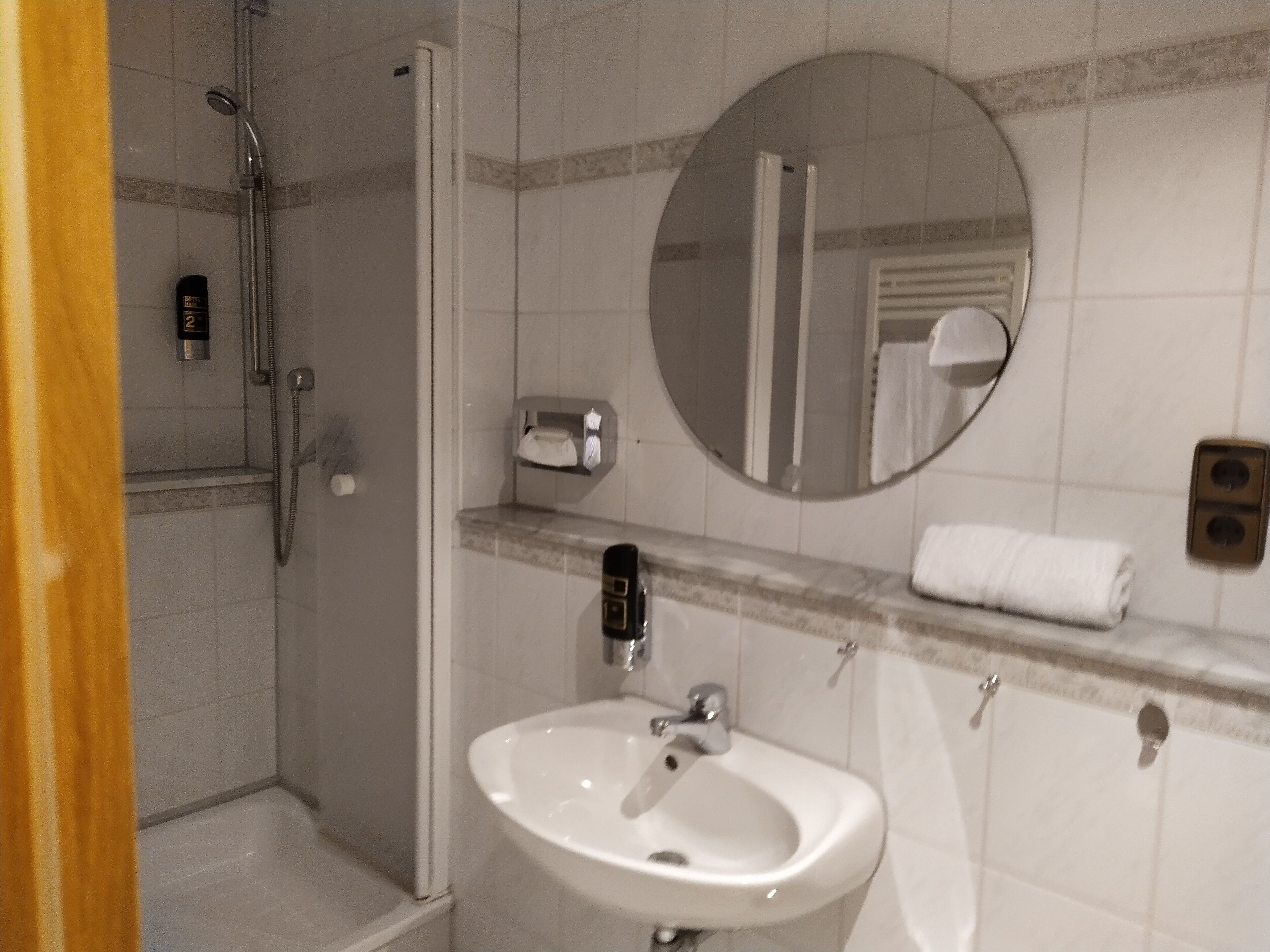 A bathroom with a shower, sink, and bathtub.