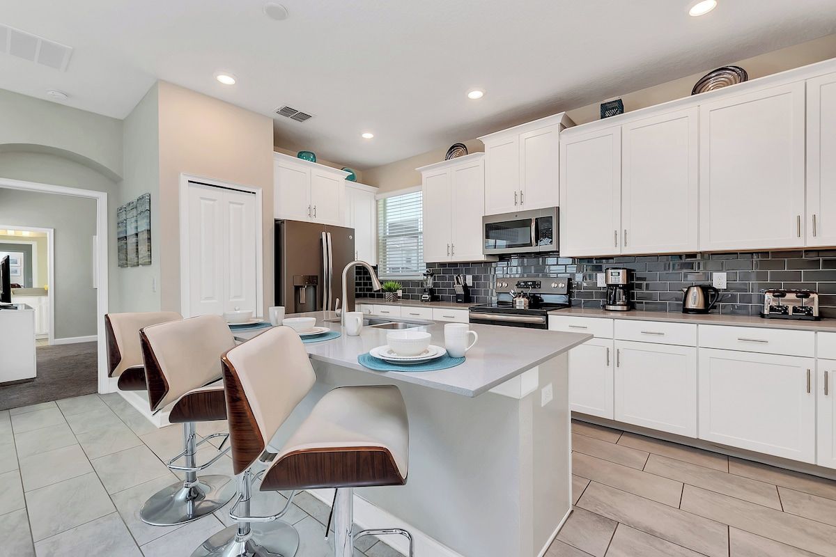 Modern Kitchen of the Home in Davenport Florida - Experience the epitome of sophistication in kitchen area - Refined design meets functionality - Stainless Steel appliances - High Chairs and Breakfast Bar
