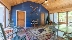 Un intérieur en bois avec un mur bleu, un plafond en bois et un coin repas comprenant des chaises et une table.