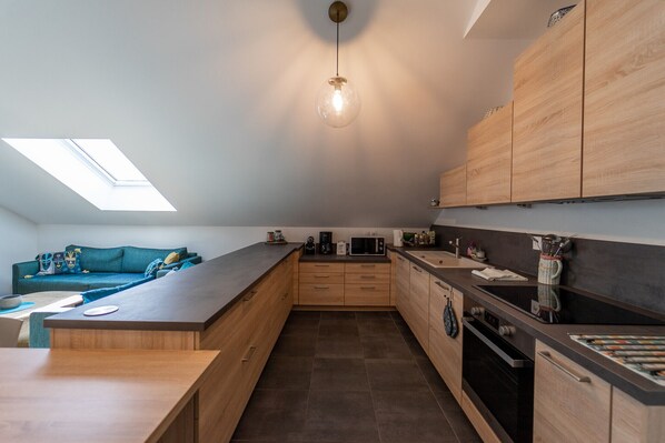 Cocina moderna con tragaluz, armarios de madera y una isla central.
