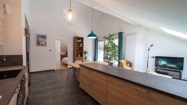Una cocina moderna con una isla central, armarios de madera y horno empotrado.