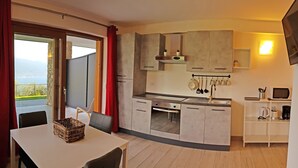 Eine moderne Küche mit Essbereich, Fernseher und Blick ins Freie.