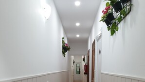 A hallway with white walls, a tiled floor, and a door at the end. - Rooms Barco (Madrid)