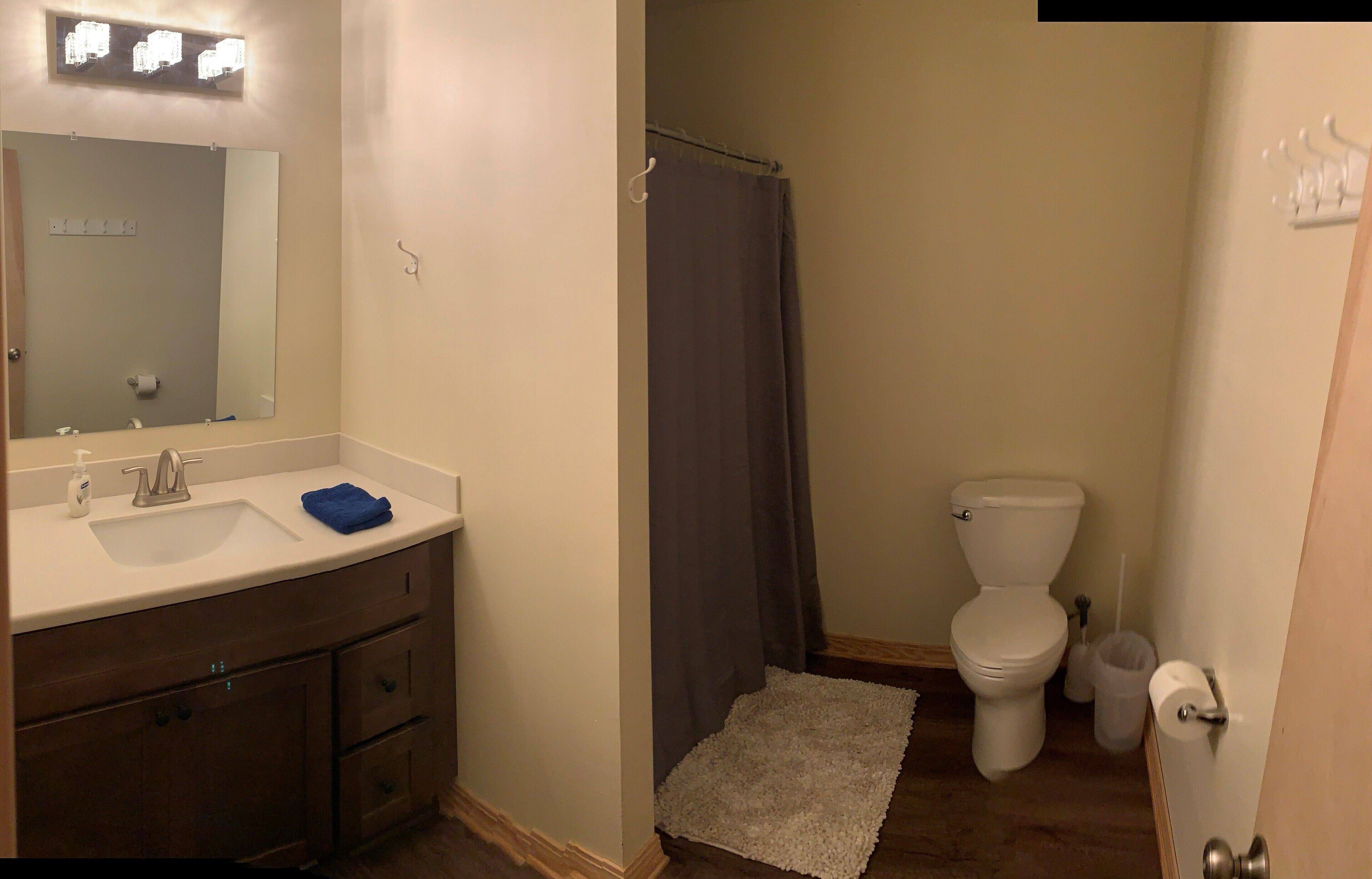 A bathroom with a sink, mirror, toilet, and shower curtain.