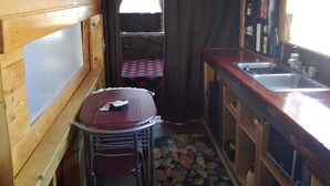 A compact kitchen with a dining area, a sink, and a small refrigerator. - Stone cottage@ La loma del chivo (Marathon)