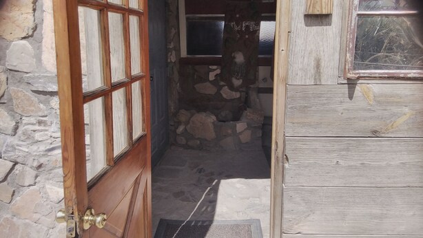 A rustic wooden door with a stone wall and a window. - Stone cottage@ La loma del chivo (Marathon)